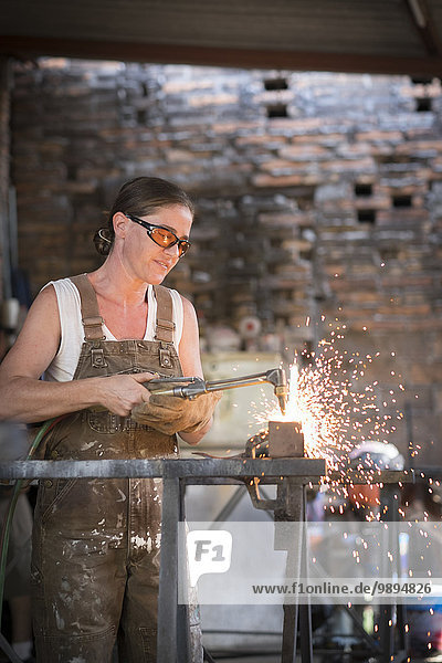 Female welder working in metal workshop
