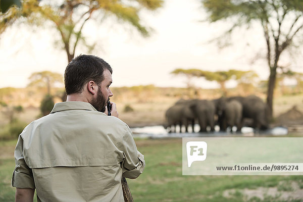 Botswana  Senyati Safari Camp  Mann fotografiert Elefantengruppe