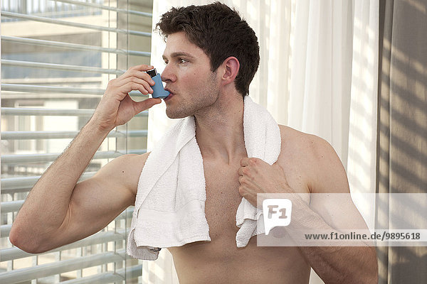 Junger Mann mit Asthma-Inhalator