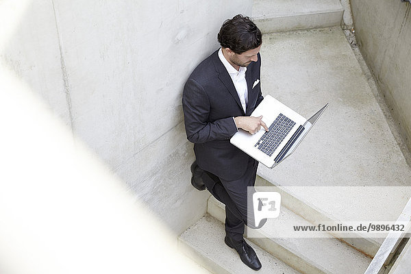 Businessman using laptop in a modern building