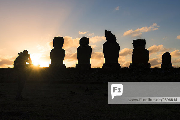 Chile  Easter Island  Man taking pictures of Moais at sunset  Ahu Tahai Complex  Rapa Nui National Park