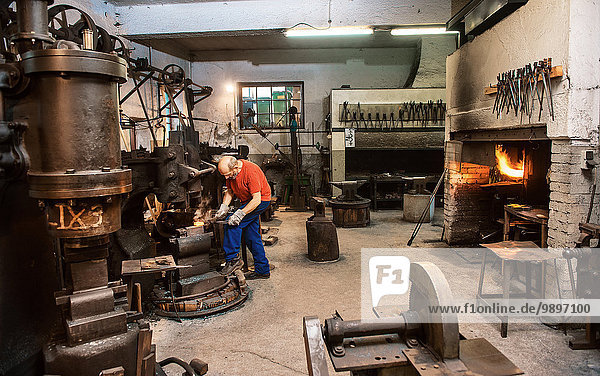 Senior blacksmith working in hammer mill