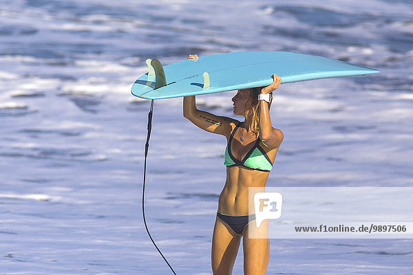 Indonesien  Bali  Frau mit Surfbrettern auf dem Kopf