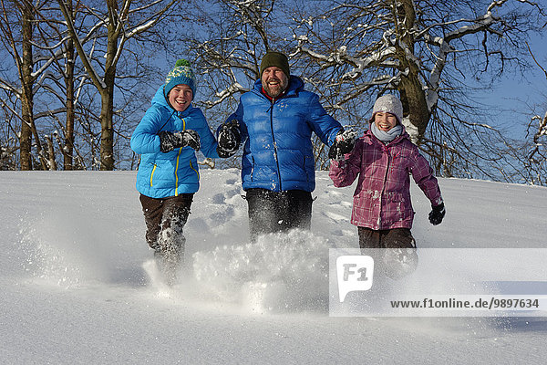Vater und zwei Kinder haben Spaß im Schnee