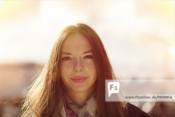Portrait of smiling young woman at backlight