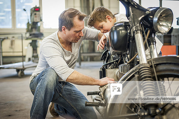 Vater und Sohn pflegen Vintage Moped