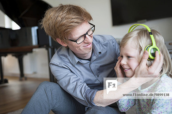 Lächelnder Vater und Tochter mit Kopfhörer