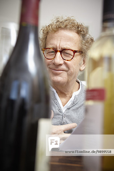 Senior Mann beim Testen von Rot- und Weißwein