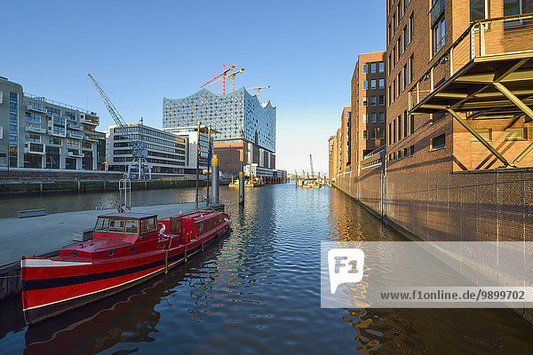Deutschland  Hamburg  Blick auf die im Bau befindliche Elbphilharmonie mit festgemachtem roten Boot im Vordergrund