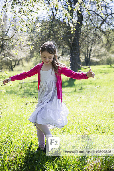 Girl dancing on a meadow in springtime