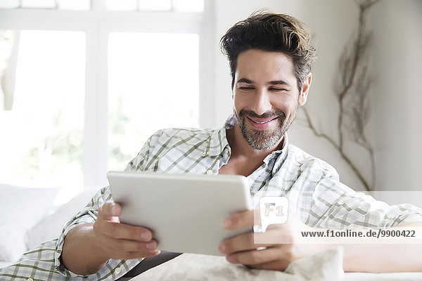 Mature man at home  using digital tablet