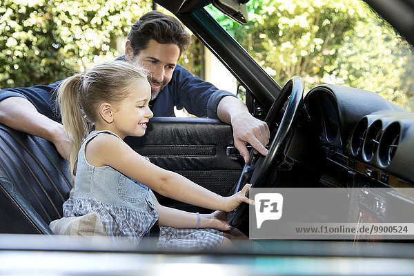 Vater zeigt Tochter sein Auto