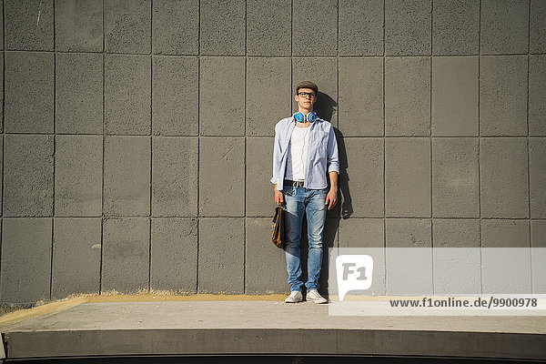 Young man holding bag standing on platform