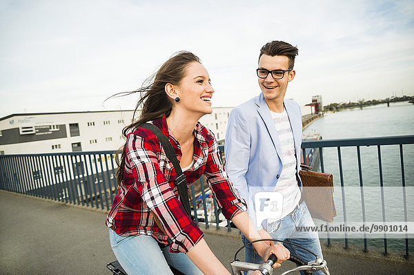 Deutschland  Mannheim  junger Mann und Frau mit Fahrrad auf Brücke