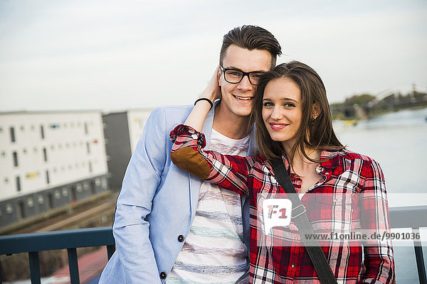 Deutschland  Mannheim  lächelndes junges Paar auf der Brücke