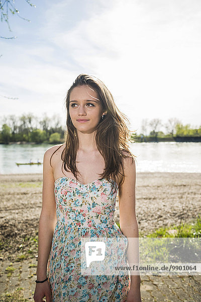 Deutschland  Mannheim  junge Frau im Sommerkleid am Rhein stehend