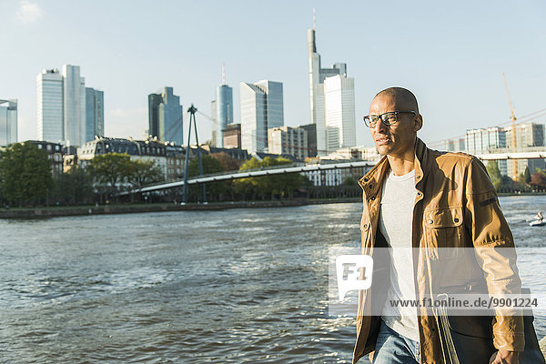 Deutschland  Frankfurt  Mann mit Aktentasche beim Spaziergang am Flussufer