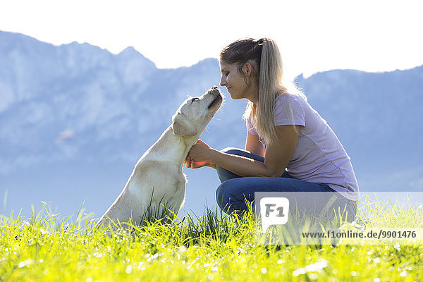 Österreich  Mondsee  Frau mit Labrador Retriever auf Alpweide