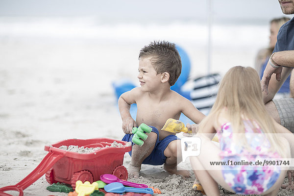 Kinder am Strand spielen mit Strandspielzeug