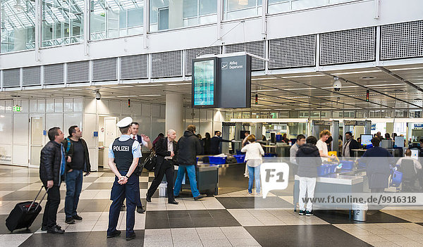 Policeman watching the security check  Munich Airport  Munich  Upper Bavaria  Bavaria  Germany  Europe