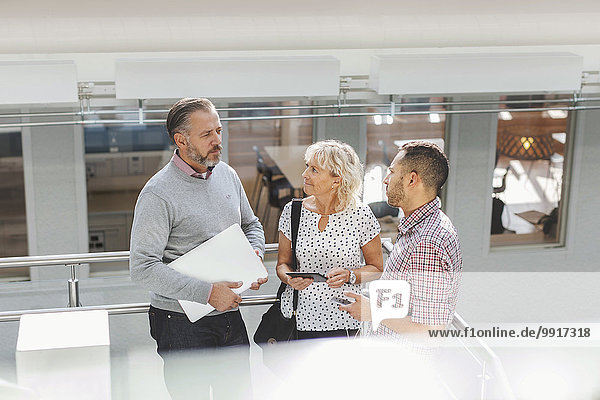 Geschäftsleute diskutieren mit dem Geländer im modernen Büro