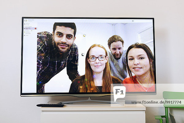 Business people on screen in video conference room at creative office