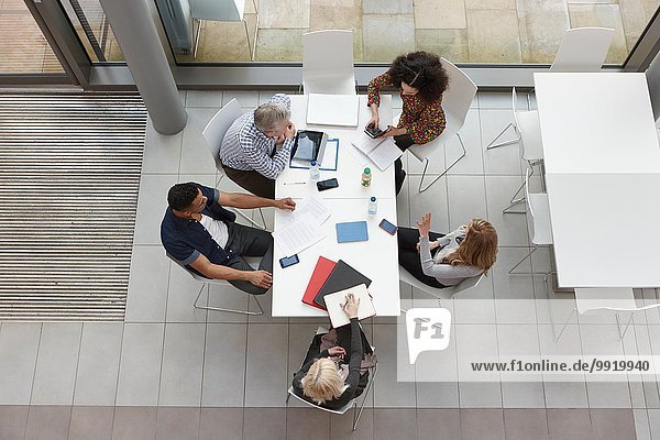 Overhead-Ansicht des Business-Teams mit Besprechung am Konferenztisch