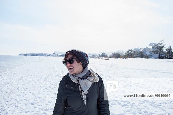 Portrait of mid adult woman  laughing  against snowy backdrop