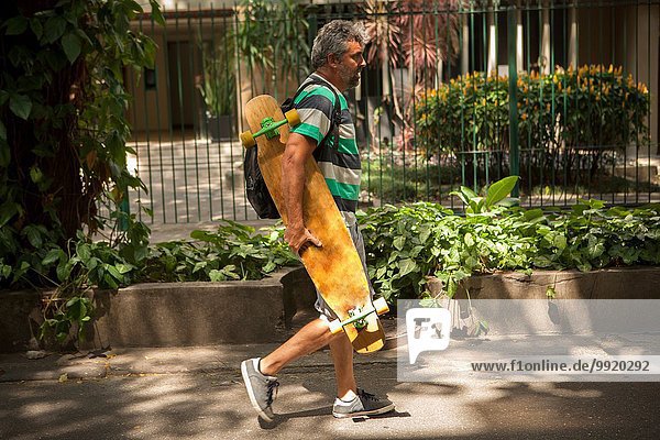 Erwachsener Mann auf dem Bürgersteig mit Skateboard  Rio De Janeiro  Brasilien