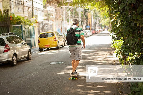 Rückansicht des reifen Mannes Skateboarding auf der Straße  Rio De Janeiro  Brasilien