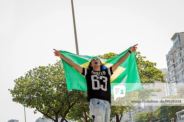 Junger Mann mit brasilianischer Flagge  Copacabana  Rio De Janeiro  Brasilien