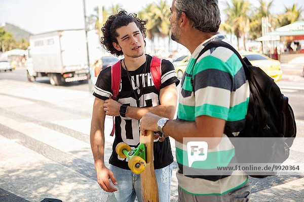 Vater und Sohn Skateboarder plaudern auf dem Bürgersteig  Copacabana  Rio De Janeiro  Brasilien