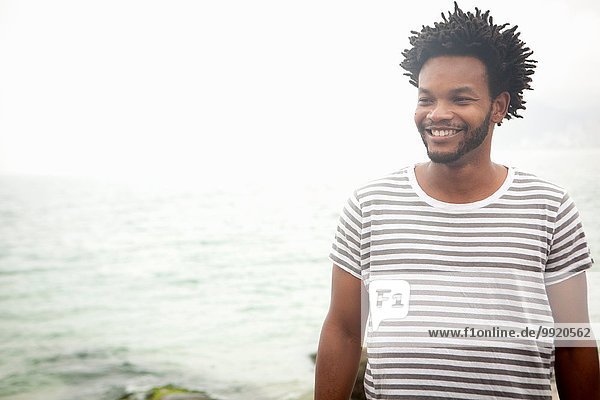 Porträt eines lächelnden erwachsenen Mannes am Strand von Ipanema  Rio De Janeiro  Brasilien