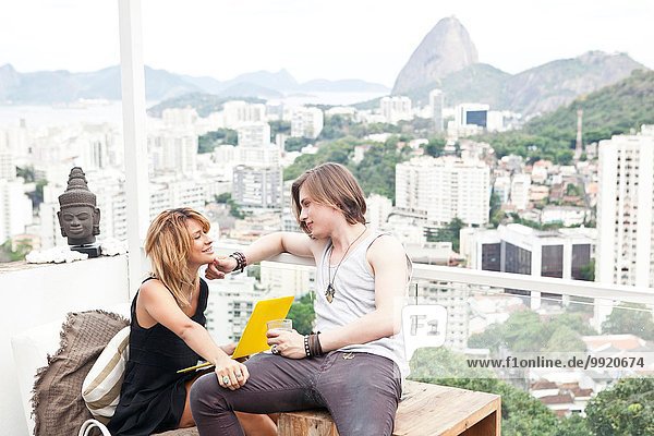 Junges Paar mit Laptop auf der Dachterrasse  Rio De Janeiro  Brasilien