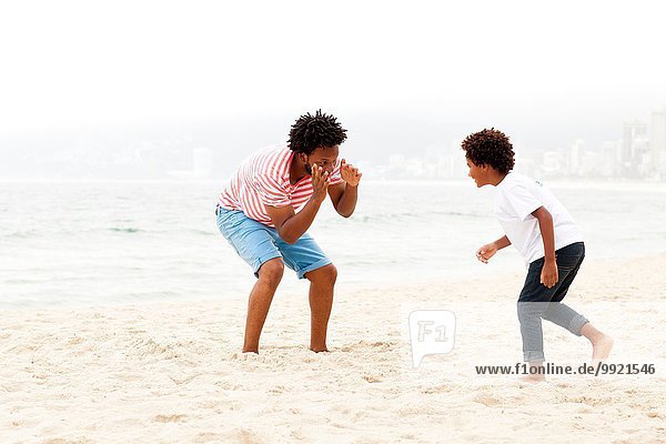 Father and son playing on beach  RIo de Janeiro  Brazil