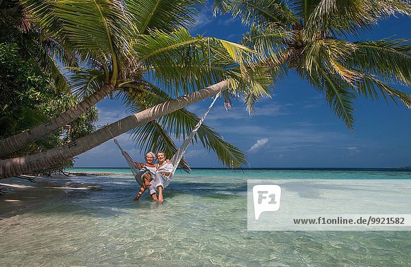 Seniorenpaar entspannt in der Hängematte,  Malediven