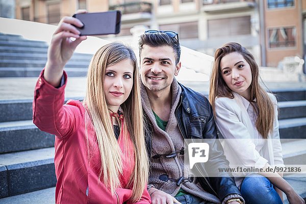 Junge Frau nimmt Smartphone Selfie mit Freunden auf der Treppe  Cagliari  Sardinien  Italien