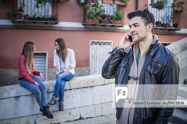 Junger Mann mit Freunden am Smartphone  Cagliari  Sardinien  Italien