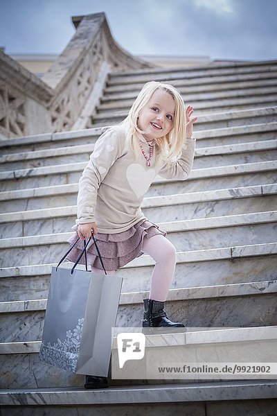 Porträt eines jungen Mädchens  das auf einer Treppe mit Einkaufstasche posiert  Cagliari  Sardinien  Italien