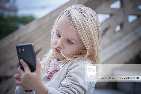 Verwirrtes junges Mädchen auf der Treppe mit Smartphone  Cagliari  Sardinien  Italien