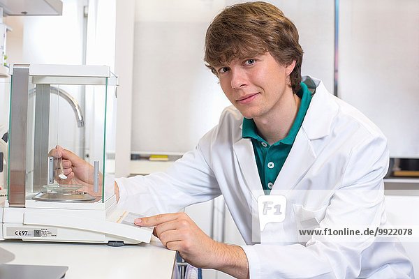 Portrait of young male pharmacist experimenting in pharmacy laboratory