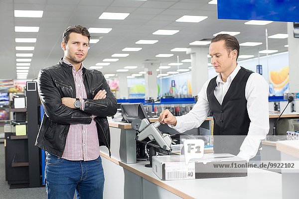 Unsure shopper paying with credit card in electronics store