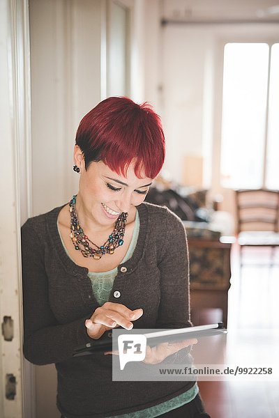 Young woman at home using digital tablet
