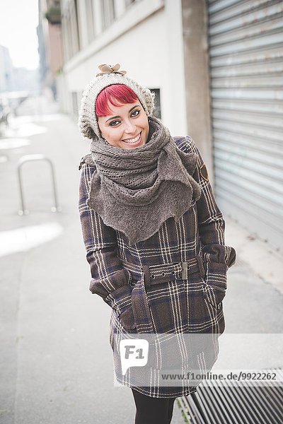 Porträt einer jungen Frau  die die Straße entlanggeht und Winterkleidung trägt.