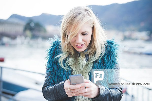 Junge Frau beim Lesen von Smartphone-Texten am Comer See  Comer See  Italien