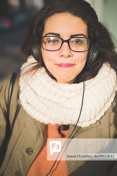 Nahaufnahme des Porträts einer jungen Frau  die eine Brille auf der Straße schwört.