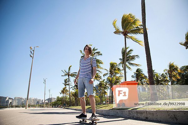 Junger Mann beim Skateboarden entlang der Straße  Blick in den niedrigen Winkel