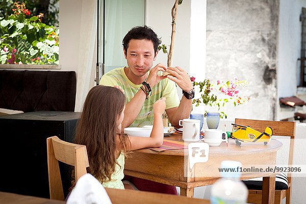 Vater und Tochter sitzen zusammen am Frühstückstisch