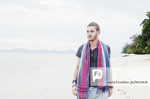 Junger Mann beim Bummeln am Strand  Kradan  Thailand