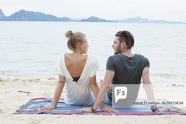 Young couple sitting on beach  Kradan  Thailand
